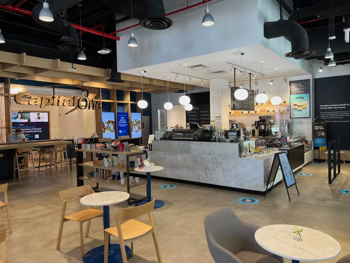 Showing Capital One Cafe Interior at West Palm Beach, Florida. Clean Starbucks like interior with wooden chairs and marble coffee tables. 