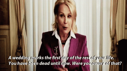Wedding planner clad a in a purple suit saying "A wedding marks the first day of the rest of your life. You have been dead until now. Were you aware of that?". A scene from  the movie the Bride Wars. 